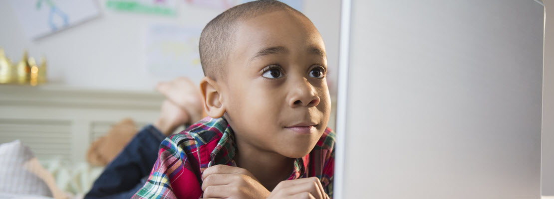 Young male Black child looking at a laptop screen
