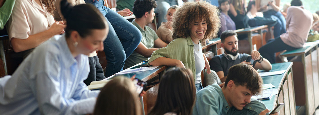 College students talking in a classroom.