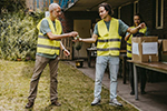 volunteers in yellow reflector vests putting items in boxes