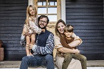 family of four sitting on front porch smiling