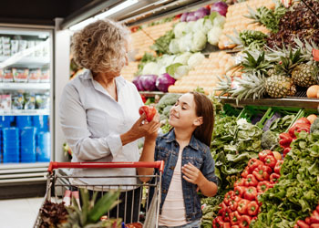 woman and child shopping for produce at a grocery store