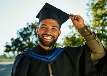 man at graduation wearing cap and gown
