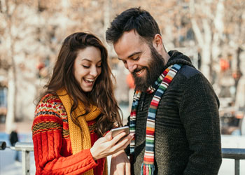 couple excitedly looking at mobile phone