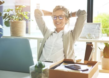 woman smiling with arms behind her head