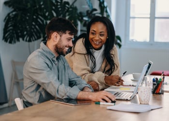 man and woman looking at computer