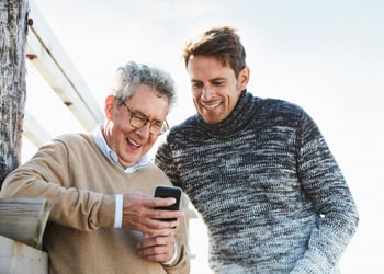 two men looking at smartphone