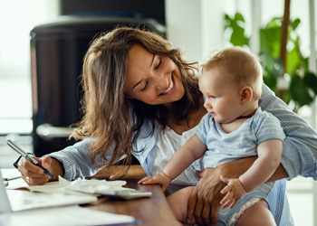 woman holding baby while she is working