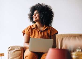 woman on computer looking out window
