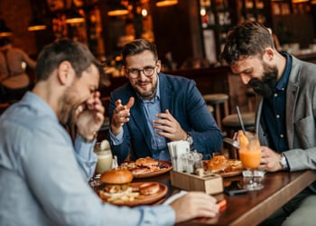 men eating and laughing at restaurant