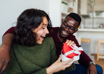 woman opening a gift from her partner