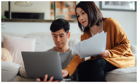 man and woman laughing and looking at tablet