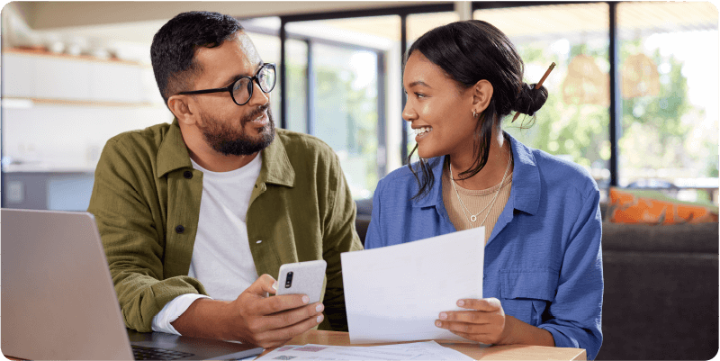 man and woman laughing and looking at tablet