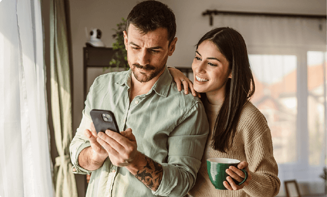 man and woman laughing and looking at tablet