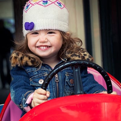 young girl in toy car