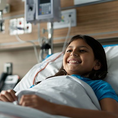 Child in hospital bed smiling