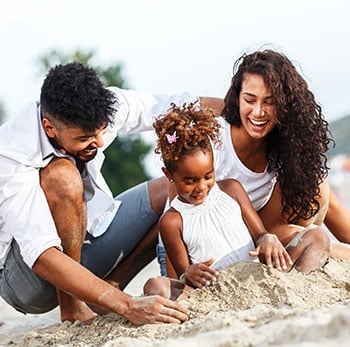 family playing in sand on beach