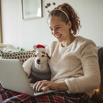 Young woman on computer with dog in lap