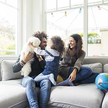 Family and dog on couch in home