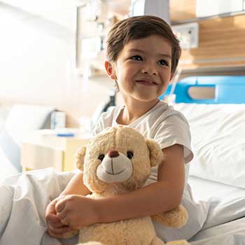 child smiling on hospital bed