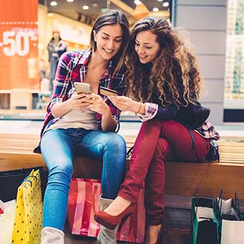 two young women shopping and looking at phones