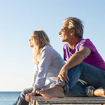 couple sitting on dock looking at water