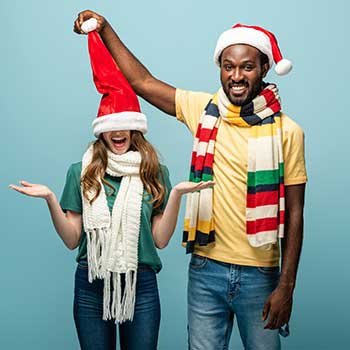 two friends laughing with Santa hats