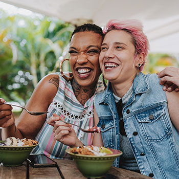 two women hugging and smiling at restaurant