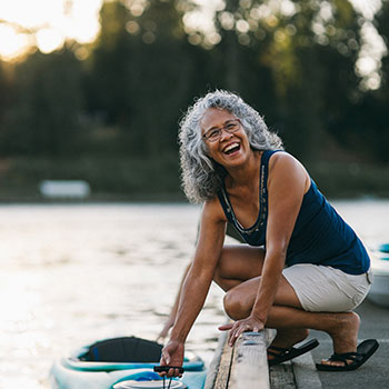 woman smiling and holding kayak