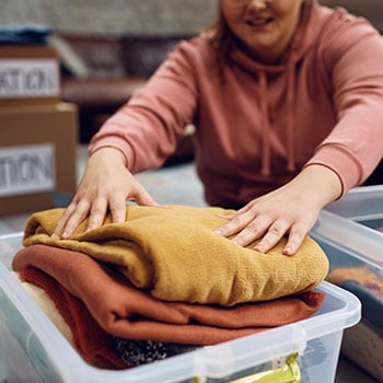 person packing sweaters and coats