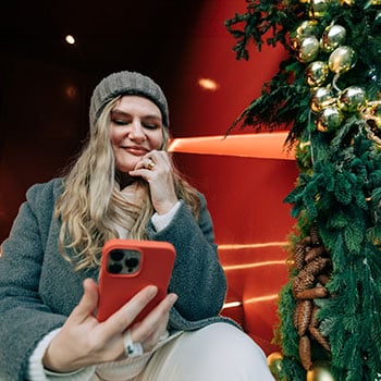 woman smiling and looking at phone
