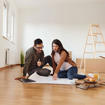 couple sitting on floor of new home