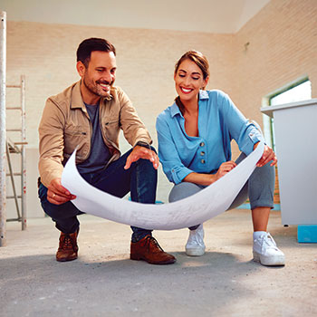 couple looking at blueprints in new home