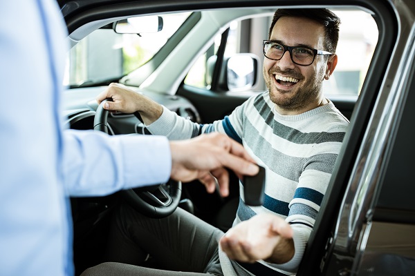 man accepting the keys to his new car