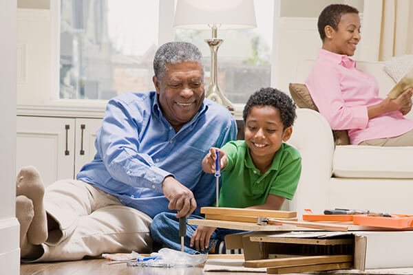 grandfather assembling furniture with grandson