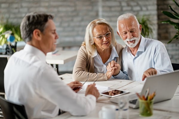 a mature couple having coffee while using their digital tablet at home