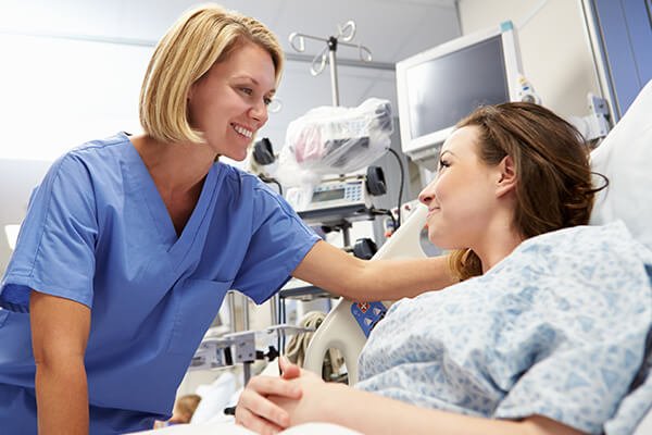 young female patient talking to nurse in emergency room