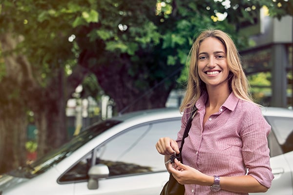 woman standing by her car holding keys