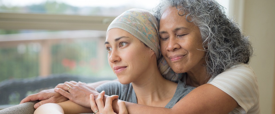 older woman embracing adult daughter in head scarf
